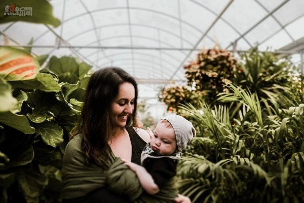 woman carrying baby inside greenhouse