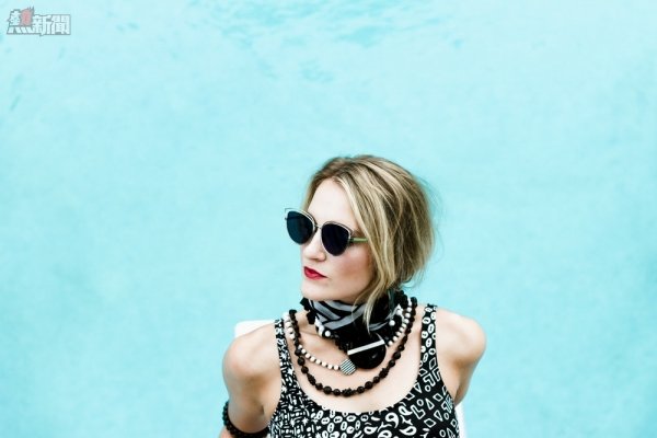 woman wearing sunglasses near blue surface