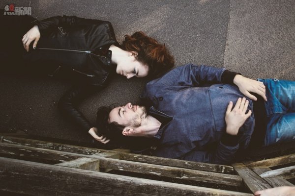 Overhead shot of man and woman laying on backs on walkway outdoors